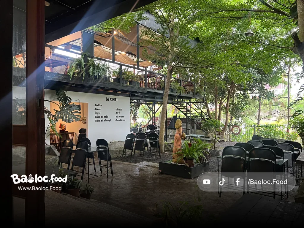 Không gian mở tại Bờ-rét-phớt Bảo Lộc với bàn ghế ngoài trời và menu treo tường